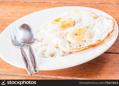 Double star eggs topped on rice with spoon and fork