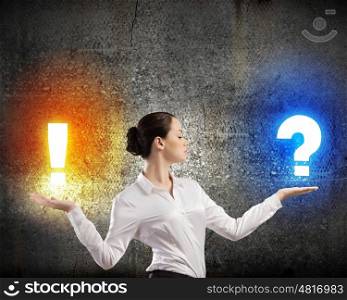 Doubt and assurance. Image of businesswoman holding exclamation and question marks on palms