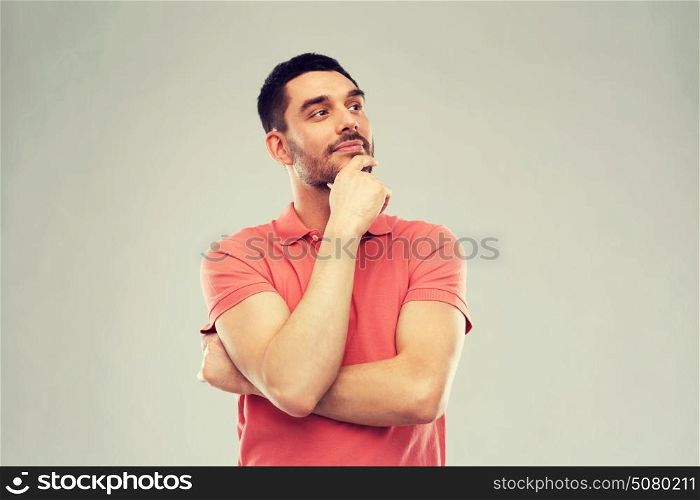 doubt, expression and people concept - man in polo t-shirt thinking over gray background. man in polo t-shirt thinking over gray background