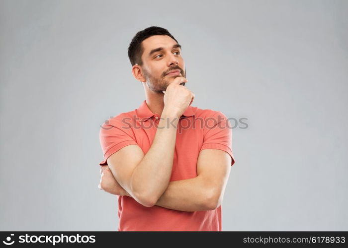 doubt, expression and people concept - man in polo t-shirt thinking over gray background