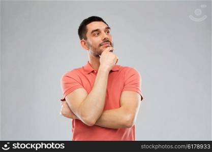 doubt, expression and people concept - man in polo t-shirt thinking over gray background