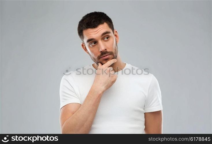 doubt, expression and people concept - man thinking over gray background