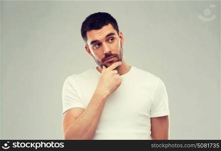 doubt, expression and people concept - man thinking over gray background. man thinking over gray background