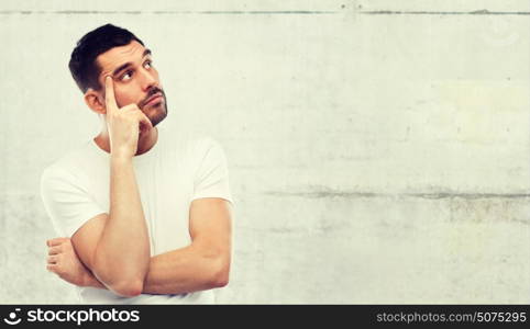 doubt, expression and people concept - man thinking over gray stone wall background. man thinking over gray background