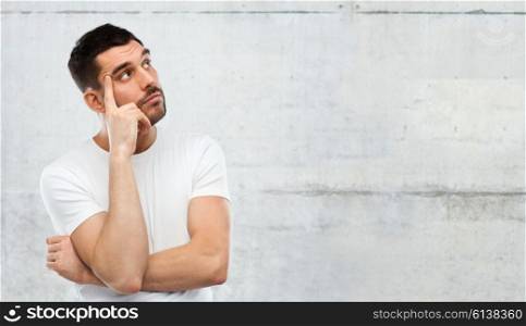 doubt, expression and people concept - man thinking over gray stone wall background