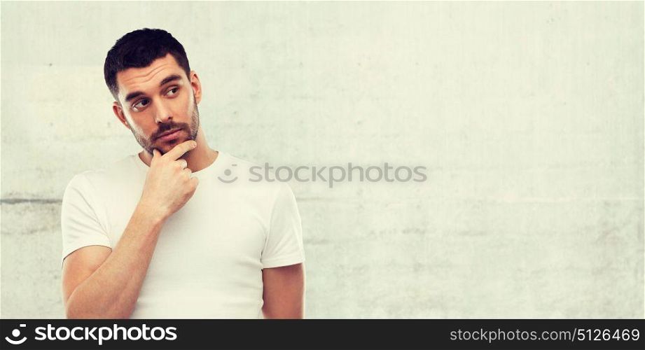 doubt, expression and people concept - man thinking over gray wall background. man thinking over gray wall background
