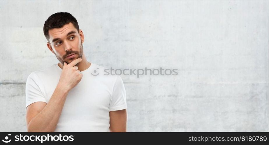 doubt, expression and people concept - man thinking over gray wall background
