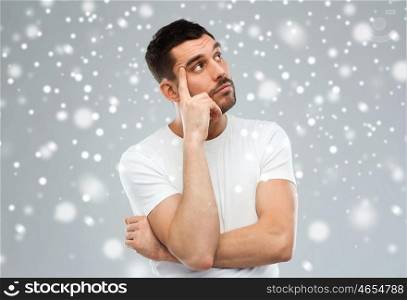 doubt, expression, winter, christmas and people concept - man thinking over snow on gray background