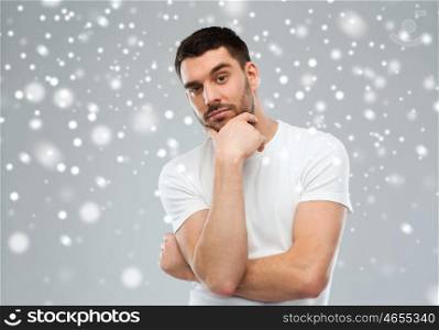 doubt, winter, christmas and people concept - man thinking over snow on gray background