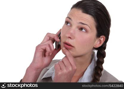 Doubtful woman talking on her mobile phone