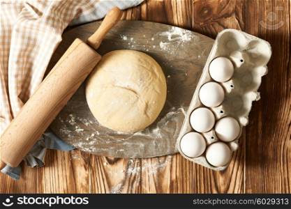 Dough and ingredients on wooden table