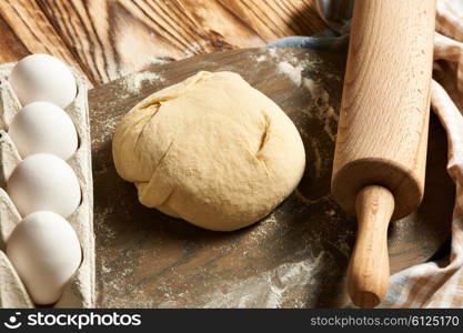 Dough and ingredients on wooden table