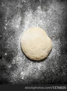 Dough background. Fresh dough with sifted flour on a rustic background.