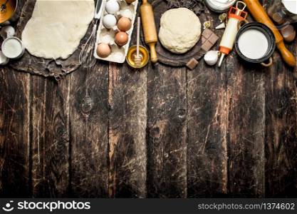 Dough background. Fresh dough with various ingredients on a wooden table.