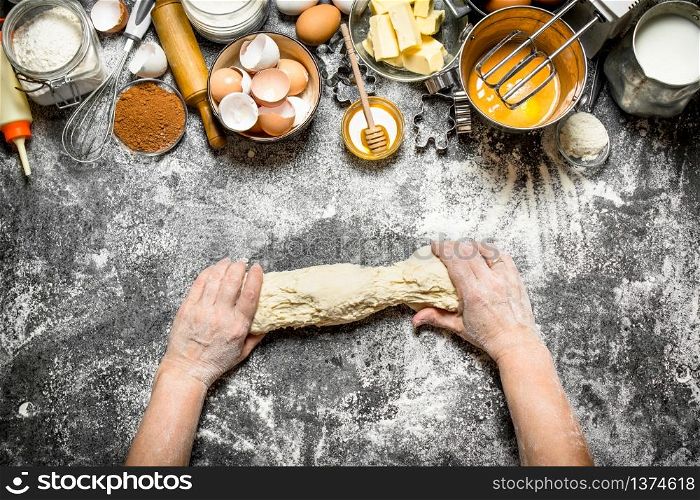 Dough background. Woman kneads dough with various ingredients on the table. On rustic background .. Dough background. Woman kneads dough with various ingredients on the table.