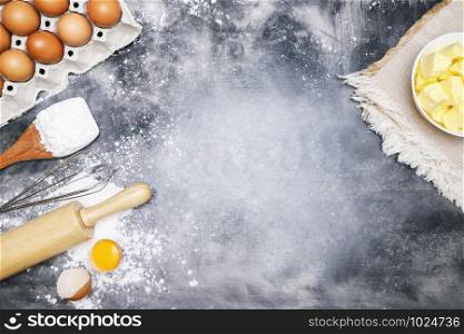 dough preparation recipe bread. Baking ingredients bakery cooking. butter on sackcloth, egg and flour on black board. flat lay on table Bare mortar cement style loft background. Top view, copy space.