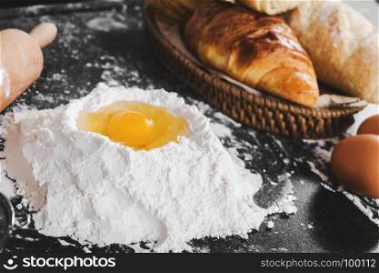 Dough preparation with eggs, flour and bread on a table in kitchen