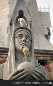 Doves and head of statue near cathedral in Ho Shi Minh, Vietnam