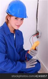 dow-eyed female electrician at work with tester