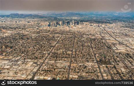 downtown los angeles skyline and suburbs from airplane and smoke from wild fires