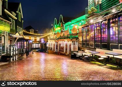 Downtown of Volendam is decorated with Christmas and New Year illuminations in the evening. Deserted pre-Christmas street of the old town on a winter night in the rain