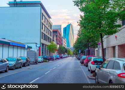 Downtown street cityscape with cars parking and European Central Bank modern building in evening sunlight, Frankfurt am Main, Germany