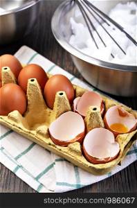 Dozen eggs in a cardboard box on a woodwn background. Chicken egg