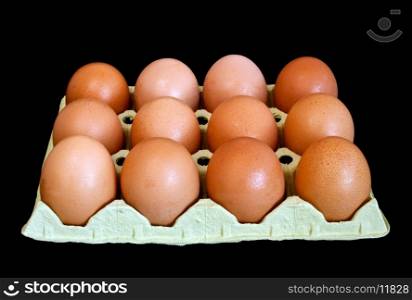 Dozen fresh brown eggs on black background