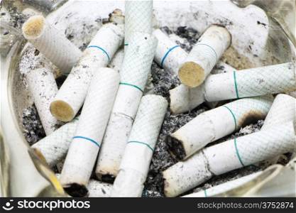 Dozen of Cigarette butt in an ashtray.