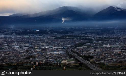 dramatic and dark process cityscape in a strom and smog layer mountain background in japan