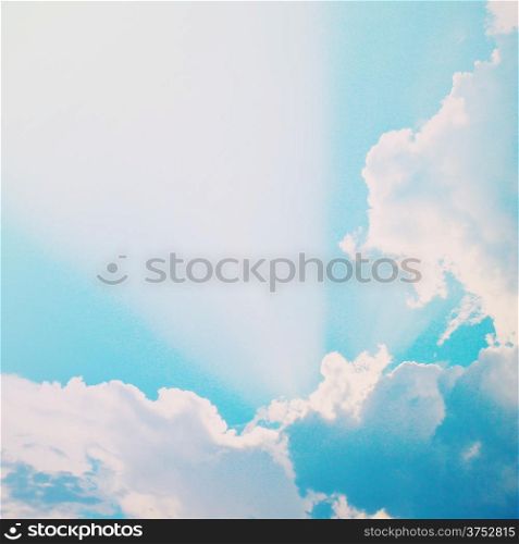 Dramatic blue sky with clouds and sunbeams, retro filter effect