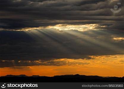 Dramatic cloudscape at sunrise with sun rays over mountain peaks, South Africa 