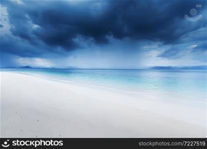 Dramatic dark storm cloud over the sea, view looking from a tranquil beach on an island. Environment, Climate change concepts. Soft focus on the storm cloud.