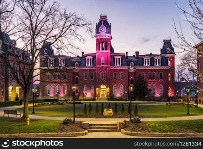 Dramatic image of Woodburn Hall at West Virginia University or WVU in Morgantown WV as the sun sets behind the illuminated historic building. Woodburn Hall at West Virginia University in Morgantown WV