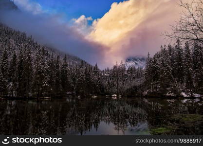 Dramatic landscape of lake in forest near mountains durring winter. Pond on the way to gruner see, Green Lake.. Dramatic landscape of lake in forest near mountains durring winter.