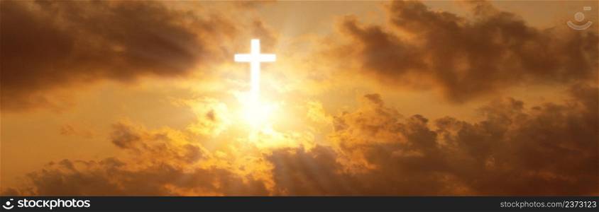 Dramatic panorama of the cross of christ in the sunrise sky, a cloud in the orange sky
