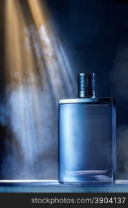 dramatic photo of perfume bottle with smoke and light rays. dramatic photo of perfume bottle with smoke