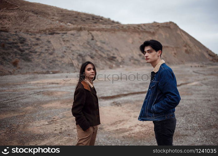 Dramatic portrait of a young brunette girl and a guy in cloudy weather. selective focus, small focus area