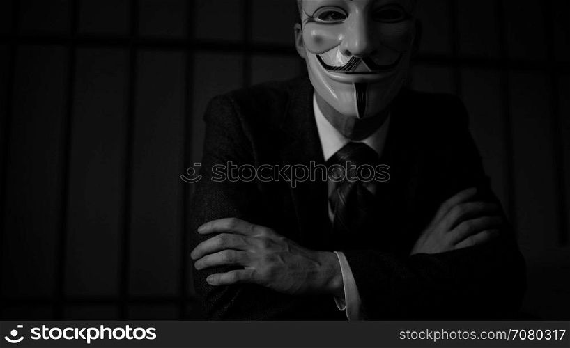 Dramatic shot of Anonymous hacker in prisonn (B/W Version)