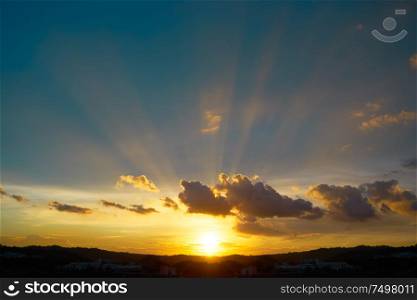 Dramatic sunlight or sun ray through the clouds at sunset sky background .