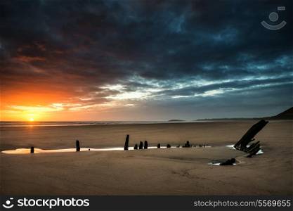 Dramatic sunset landscape over shipwreck on Rhosilli Bay beach