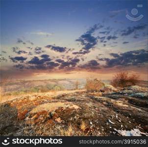 Dramatic sunset on a mountain plateau with red stones