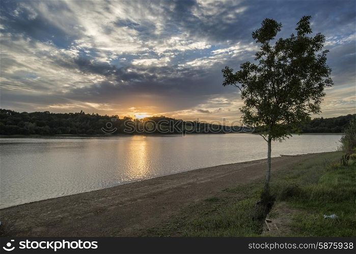 Dramatic sunset over calm lake in Summer in English countryside