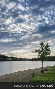 Dramatic sunset over calm lake in Summer in English countryside