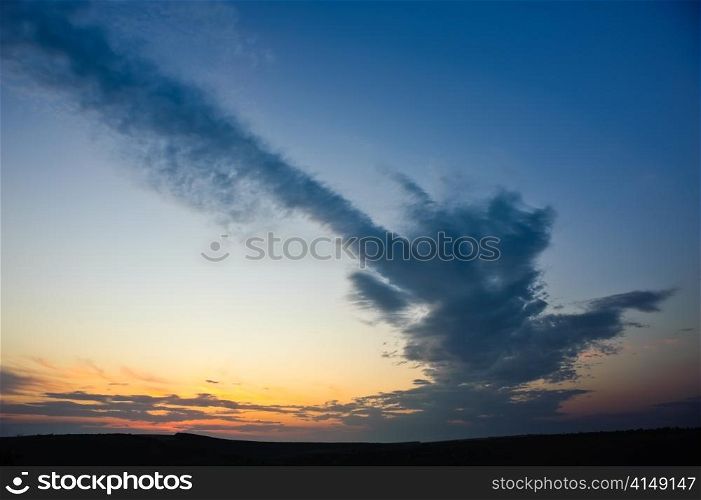 dramatic sunset with strange cloud over dark horizon. dramatic sunset