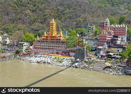 Draw bridge and temples in Laxman Jhula at the Ganga in India