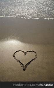 draw heart in the wet sand at the beach