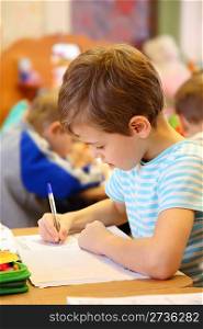 Drawing boy in kindergarten
