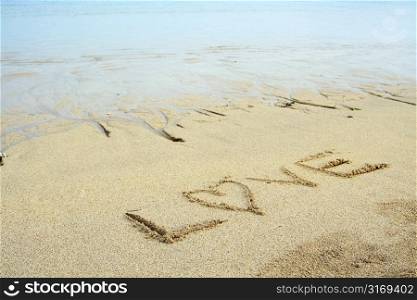 Drawing of letters of LOVE on a sandy beach