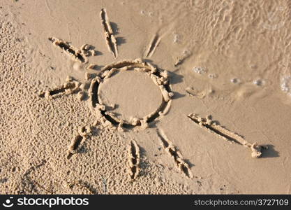 Drawn on the sand of the sun, which washes off a wave